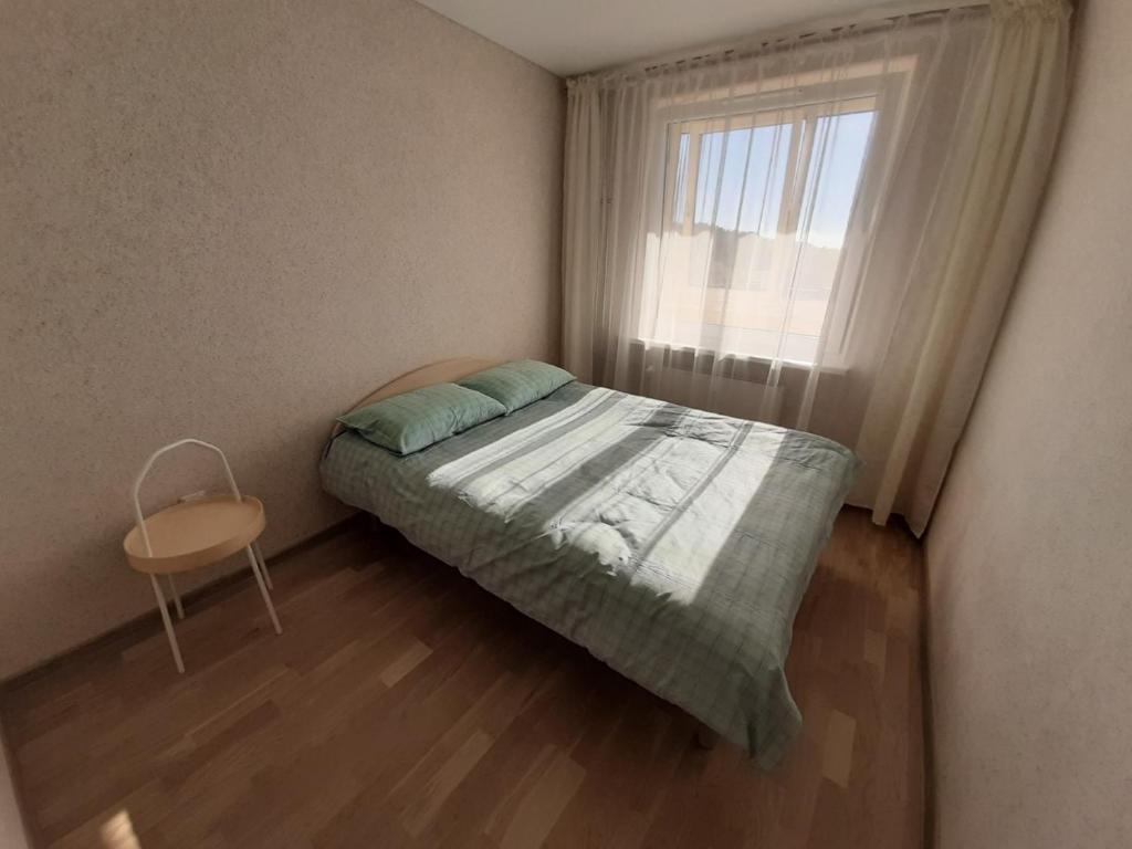 a small bedroom with a bed and a window at Ramuma in Anykščiai