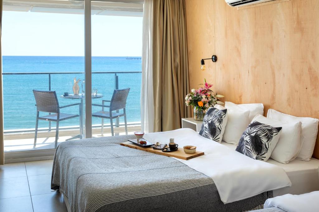Sun Hotel By En Vie Beach في ألانيا: غرفة فندقية مع سرير مطلة على المحيط