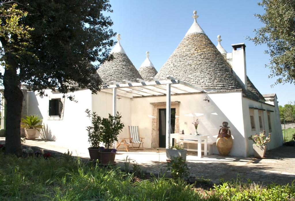 a white cottage with a thatched roof at Trulli sul vignale in Masseria Santalachicca in Martina Franca