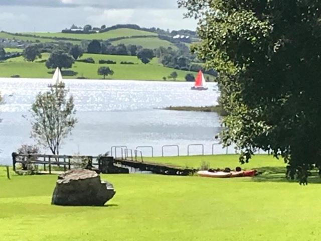 a large body of water with a boat in the grass at St Kyrans Guest House in Virginia