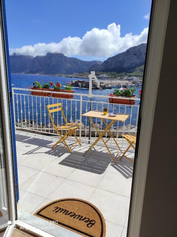 a balcony with a table and chairs and a view of the water at La casa di Giulio - holiday home in Isola delle Femmine
