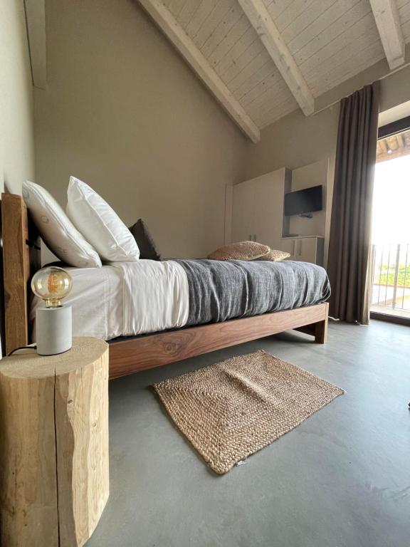 a bedroom with a large bed with a wooden frame at Il GrecAle - Ristorante e camere in La Morra