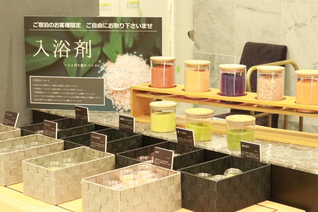 a display of different colored jars on a shelf at Hotel Fujita Fukui in Fukui