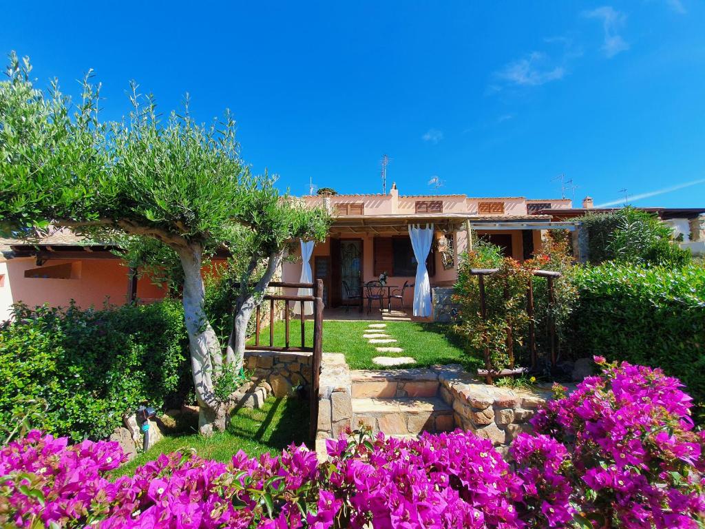 una casa con fiori viola nel cortile di Casa Sole a Villasimius