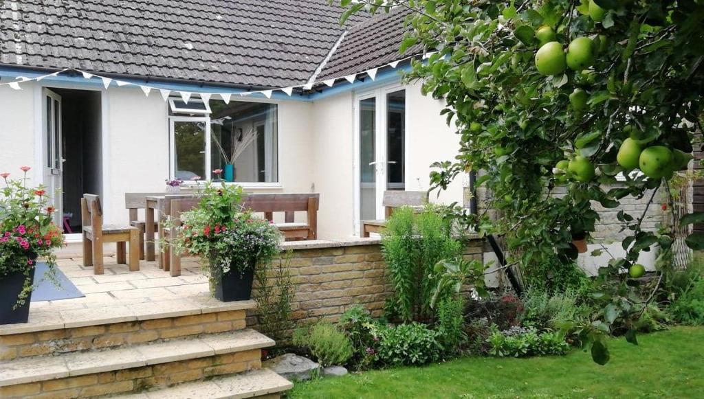 Casa con patio con mesa y sillas en Wedgewood Annexe - All the comforts of home, en Mere