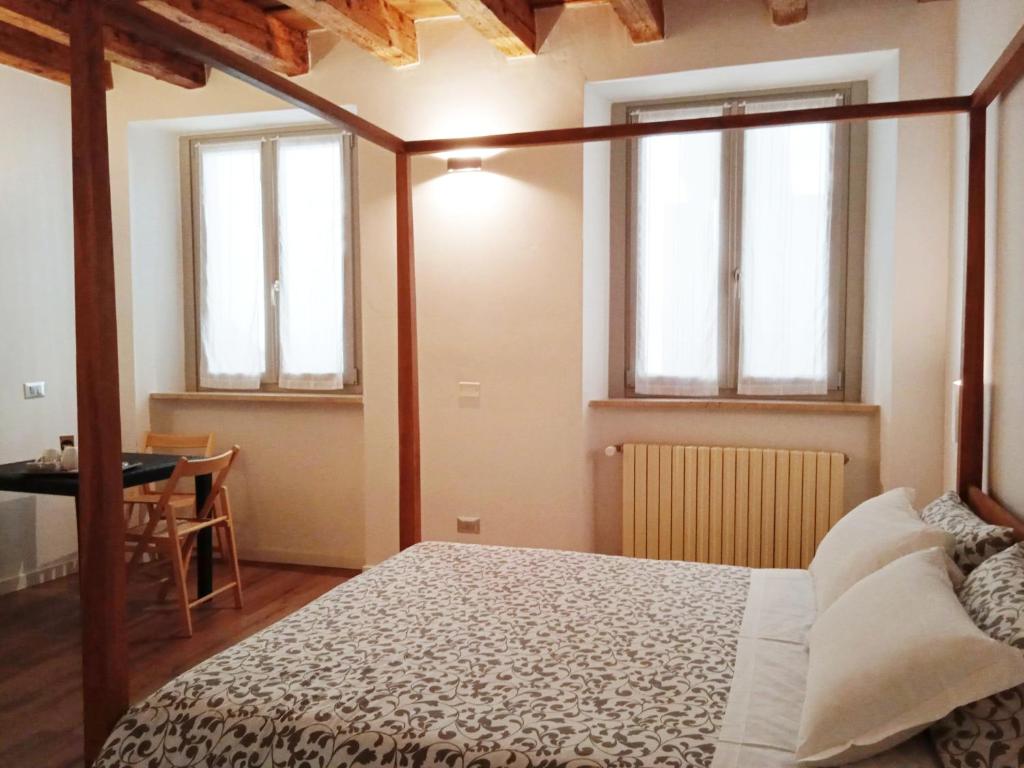 sypialnia z łóżkiem, stołem i oknami w obiekcie Moira Rooms w Bergamo
