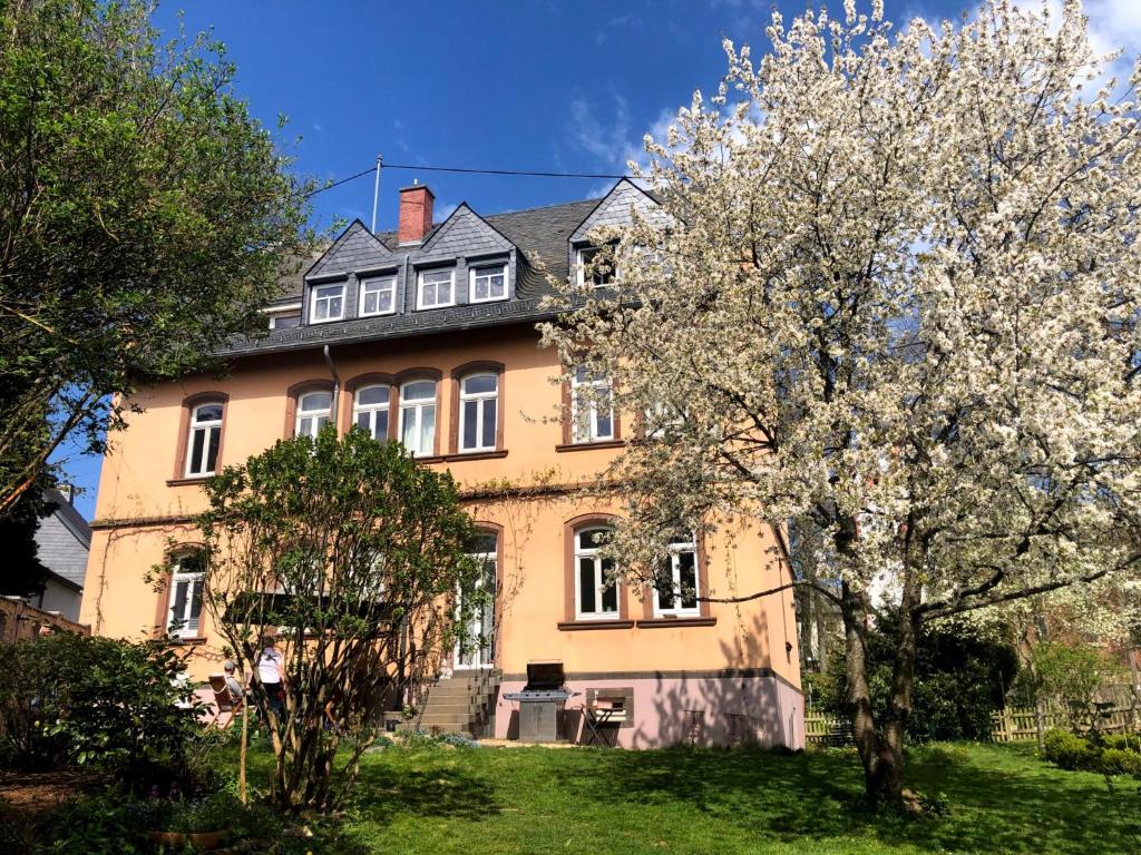 GondershausenにあるAltes Pfarrhaus Gondershausenの木々が目の前に広がる黄色い家