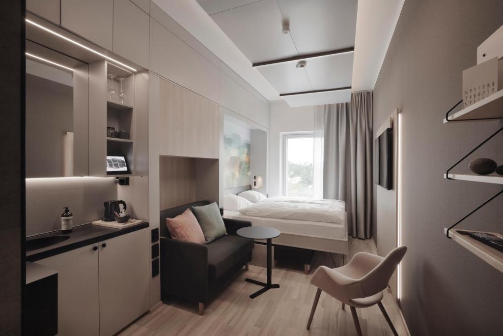 a small room with a bed and a chair at VALO Hotel & Work Helsinki in Helsinki