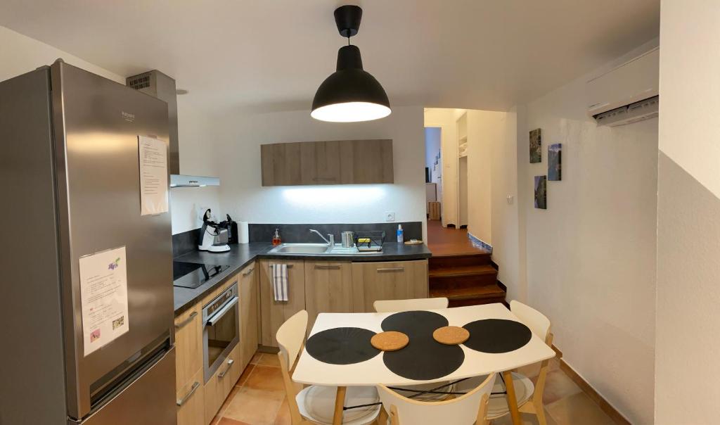 a kitchen with a table and chairs and a refrigerator at Maison de village au pays des lavandes à Valensole in Valensole