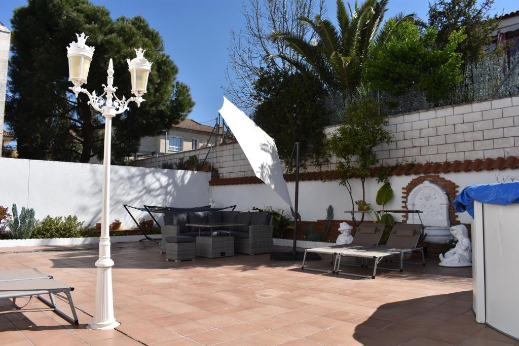 ein Straßenlicht auf einer Terrasse mit einem Tisch und Stühlen in der Unterkunft Apartamentos R66 in Cáceres