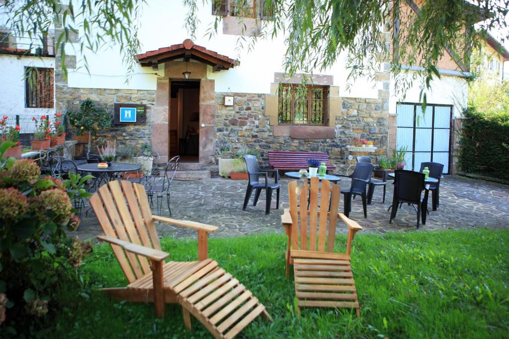 
a wooden bench sitting in front of a house at Hostal Rural Donamariako Benta in Donamaría
