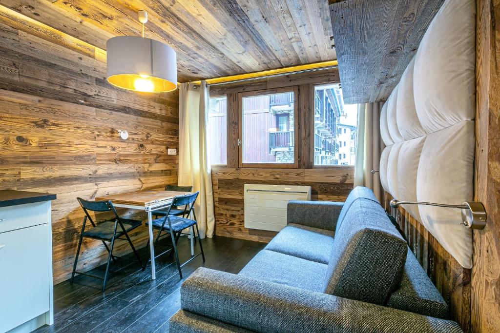 uma sala de estar com um sofá e uma mesa em Magnifique petit studio 2-3 personnes dans l'Hyper Centre skis aux pieds vue front de neige em Val dʼIsère