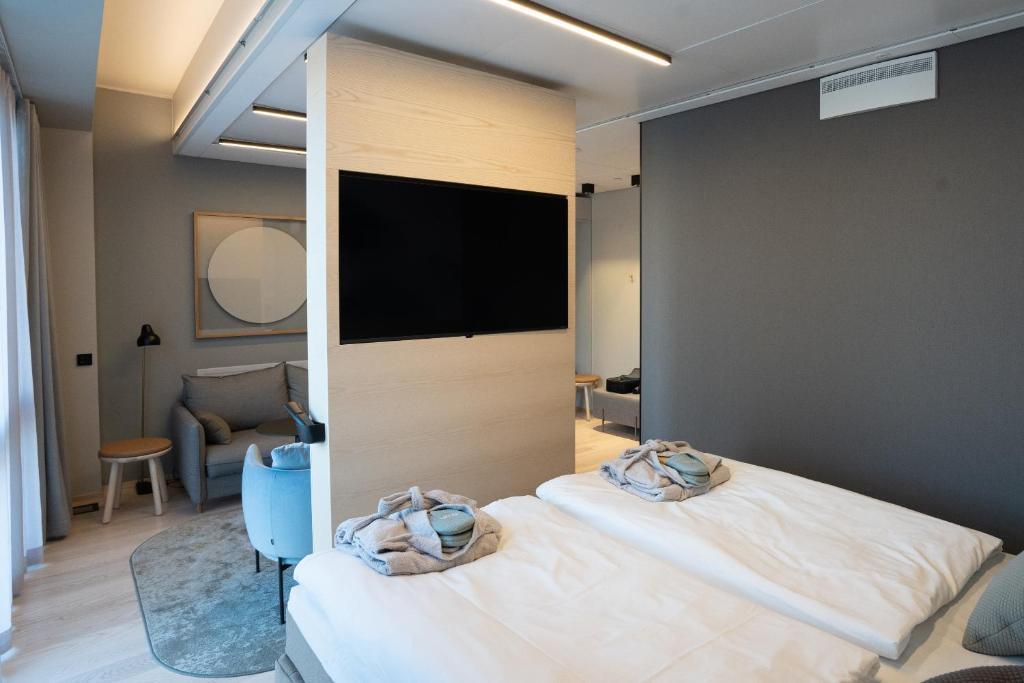 a bedroom with two beds and a flat screen tv at VALO Hotel & Work Helsinki in Helsinki