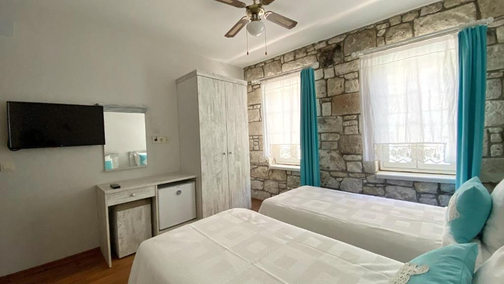 a bedroom with two beds and a flat screen tv at Oberj d'Azur Alaçatı in Alaçatı