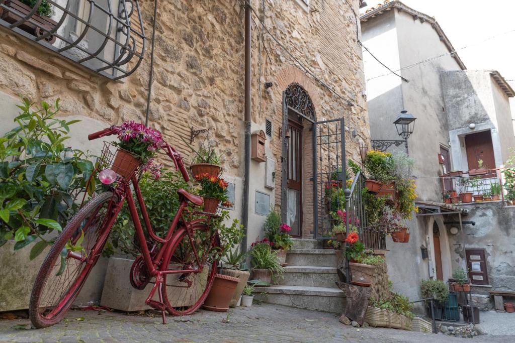 a red bike parked in front of a building with flowers at MGResidenceTolfa 1 in Tolfa