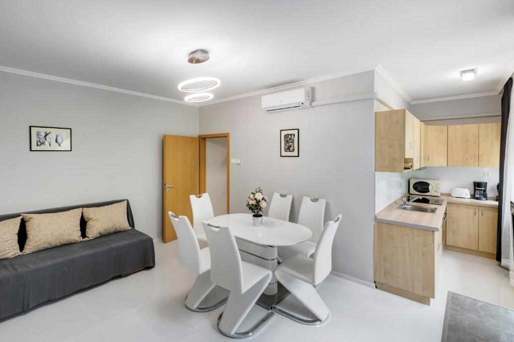 eine Küche und ein Wohnzimmer mit einem Tisch und Stühlen in der Unterkunft Fonyód Beach Apartment in Fonyód