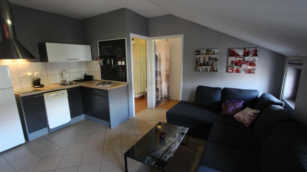 salon z kanapą i kuchnią w obiekcie Apartment Vdovjak w mieście Malinska