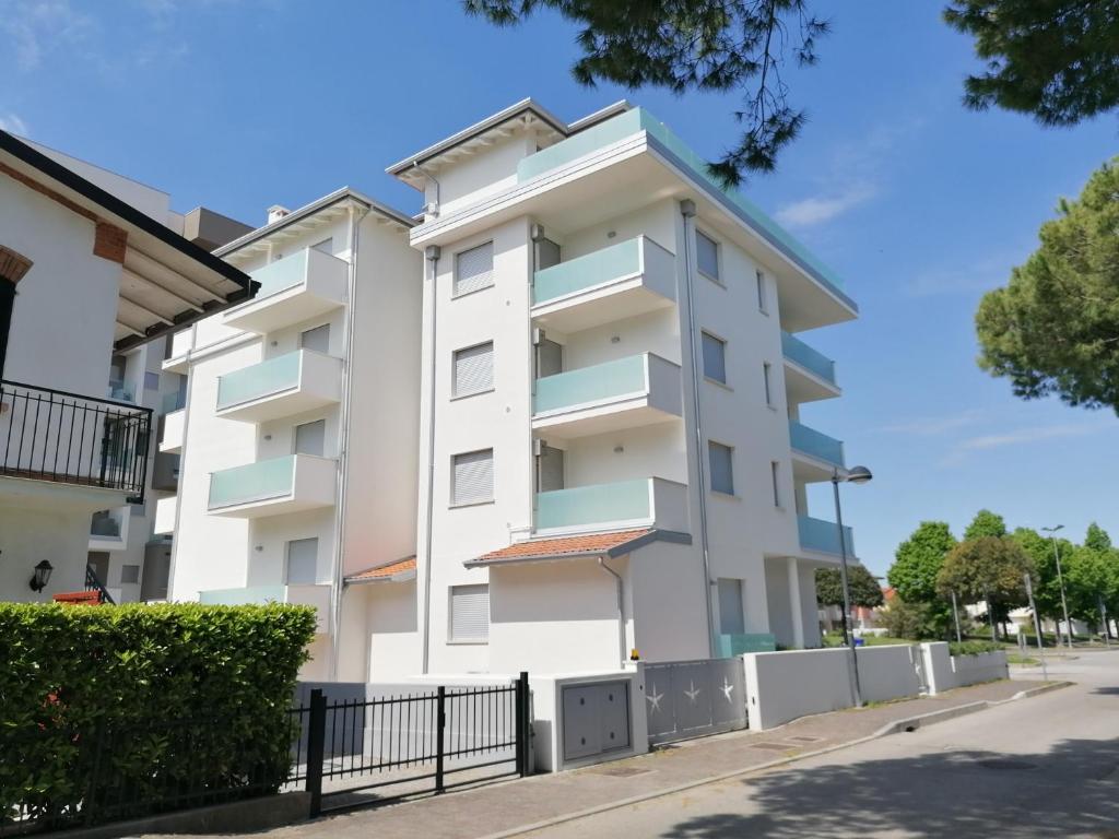 a white apartment building on a street at Residence Antares in Caorle