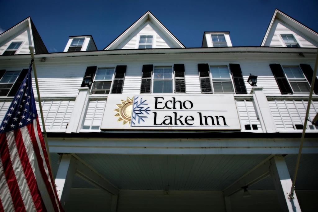 um sinal para Echo Lake Inn na frente de um edifício em Echo Lake Inn em Tyson