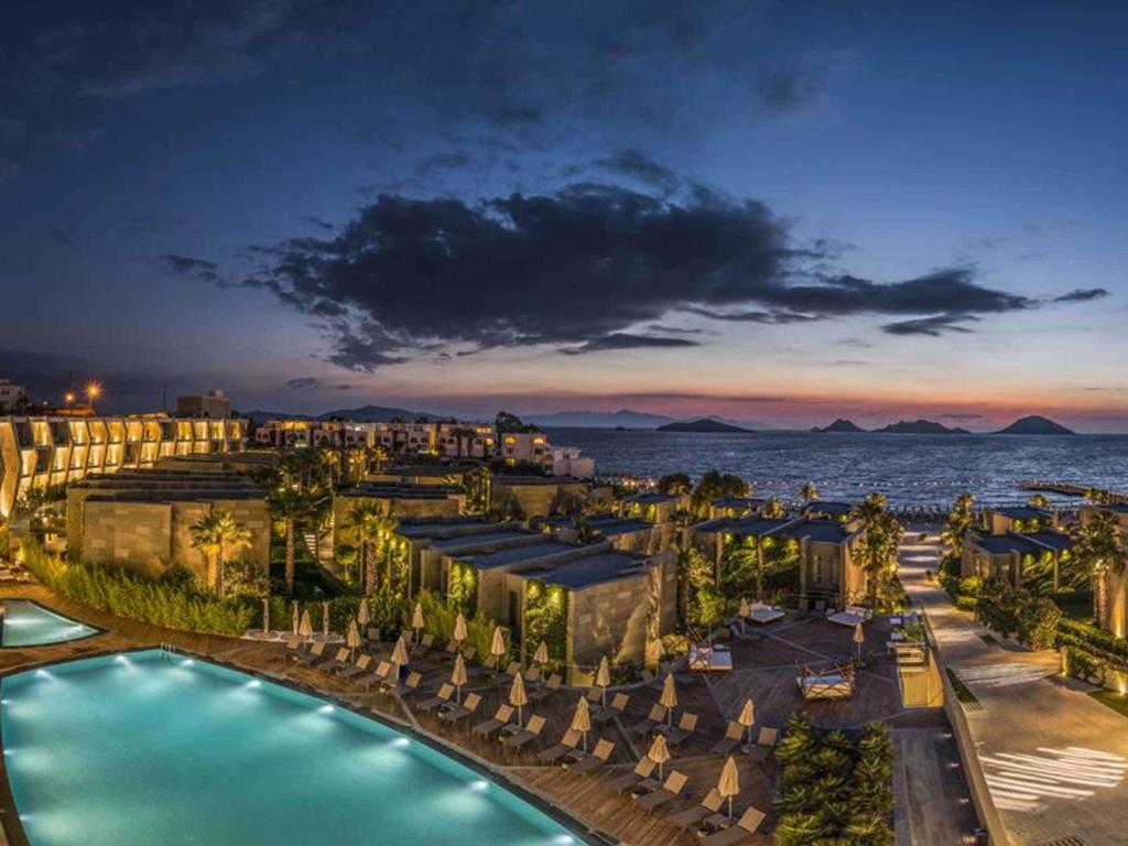 a view of a resort with a pool and the ocean at Swissôtel Resort Bodrum Beach in Turgutreis