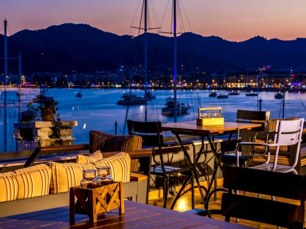 einen Balkon mit Tischen und Stühlen und Hafenblick in der Unterkunft Sunset Boutique Hotel Marmaris in Marmaris