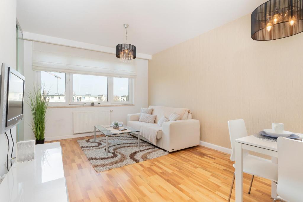 a living room with a white couch and a table at Marina Primore Apartments by Renters in Gdańsk