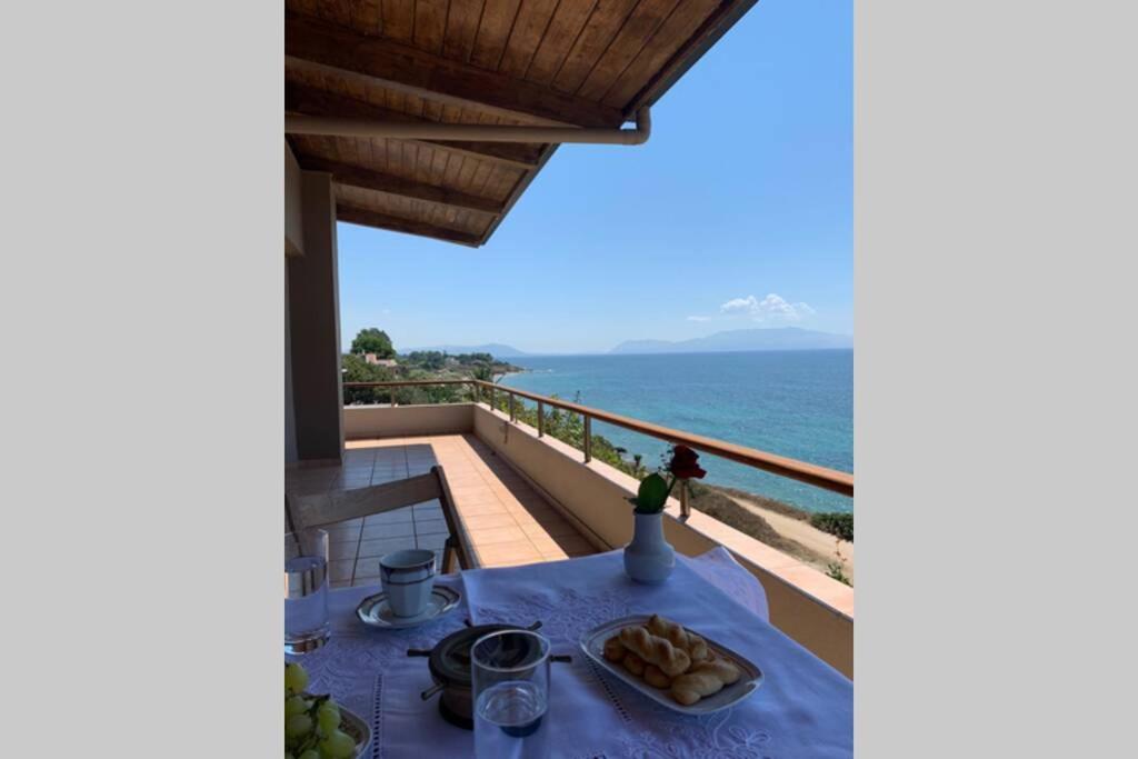 una mesa en un balcón con el océano en el fondo en 360º suite with endless views to the Ionian Sea, en Mitikas