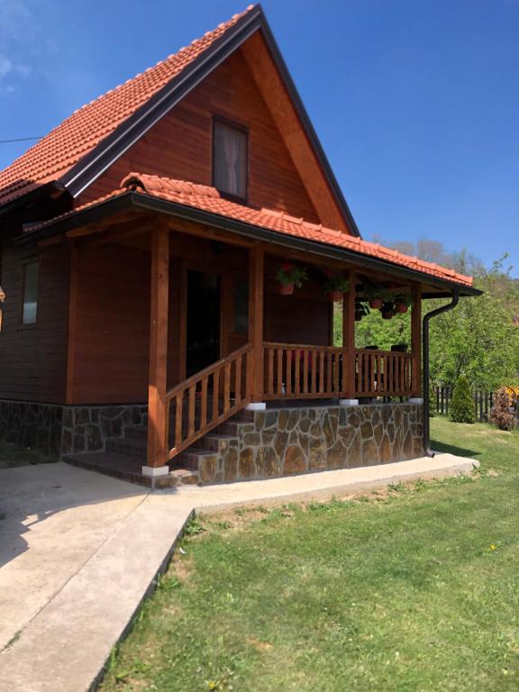 a log cabin with a porch and a balcony at Apartments Bogdanović in Mokra Gora