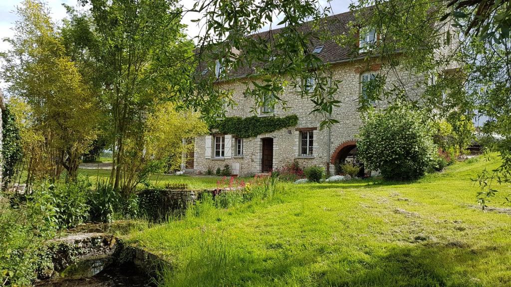 an old stone house with a garden in the yard at Moulin de Giboudet Chambres d'hôtes in Bazainville