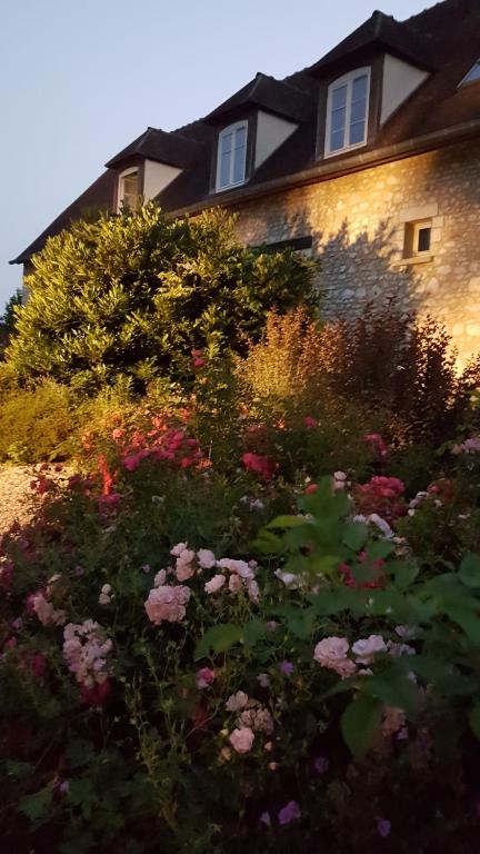 a garden with flowers in front of a house at Moulin de Giboudet Chambres d&#39;hôtes in Bazainville