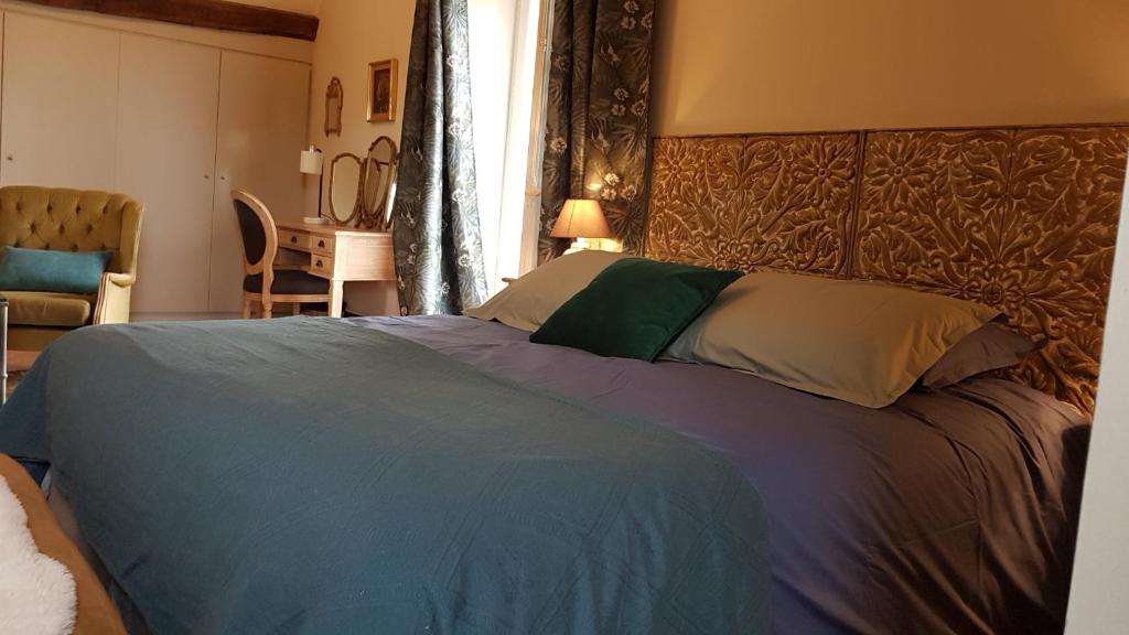 a bedroom with a large bed with a blue blanket at Moulin de Giboudet Chambres d&#39;hôtes in Bazainville