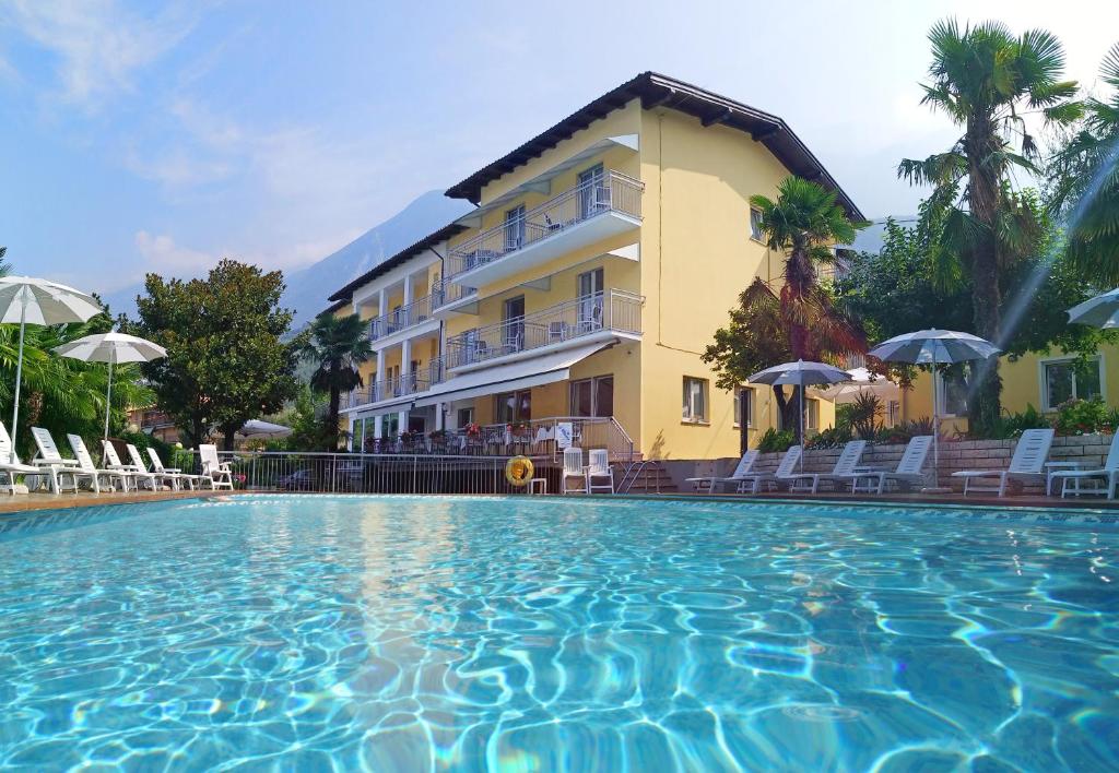 a hotel with a swimming pool in front of a building at Hotel Casa Serena in Malcesine