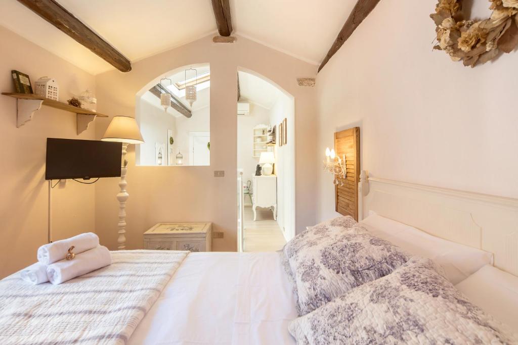 La Mansarda Segreta Mood Apartment في فيرونا: غرفة نوم بسرير ابيض ومرآة