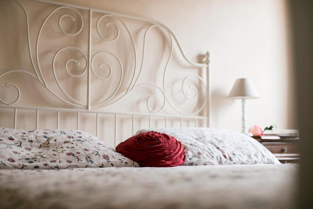 a white bed with a red ball of yarn on it at BB Le Gemme in Dolceacqua