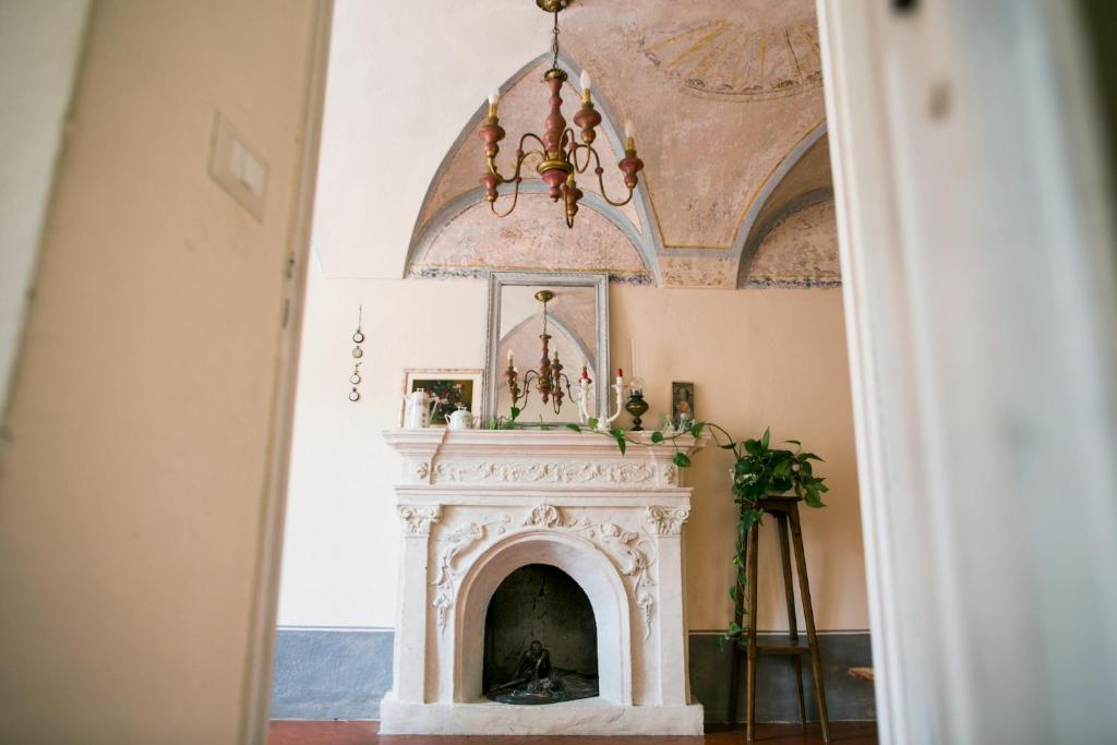 a fireplace in a living room with a chandelier at BB Le Gemme in Dolceacqua