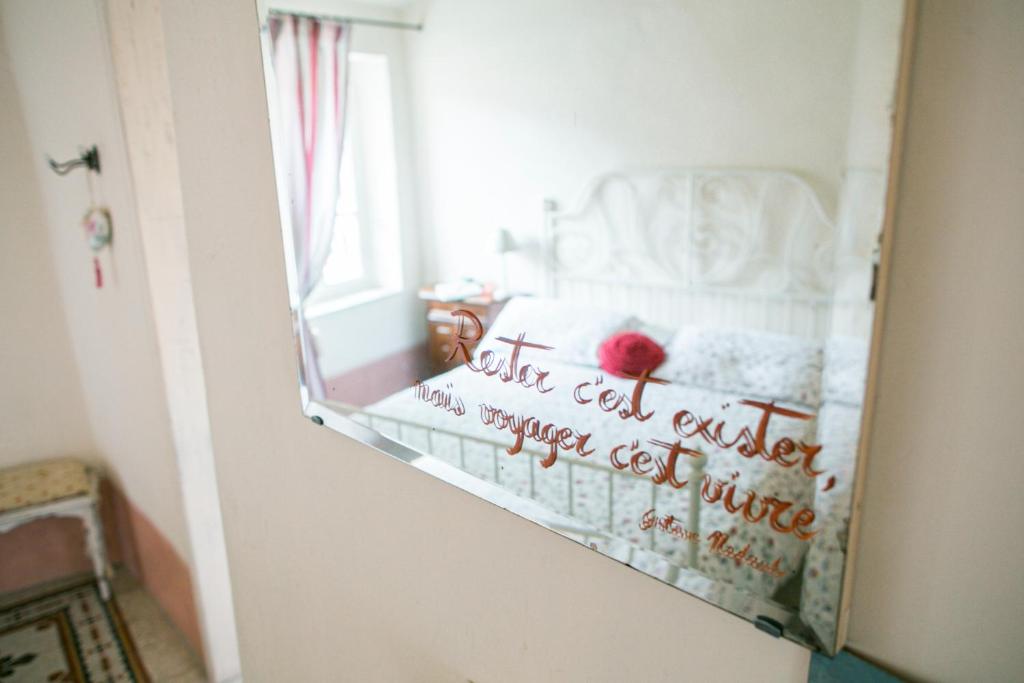 a mirror in a room with a bed with writing on it at BB Le Gemme in Dolceacqua