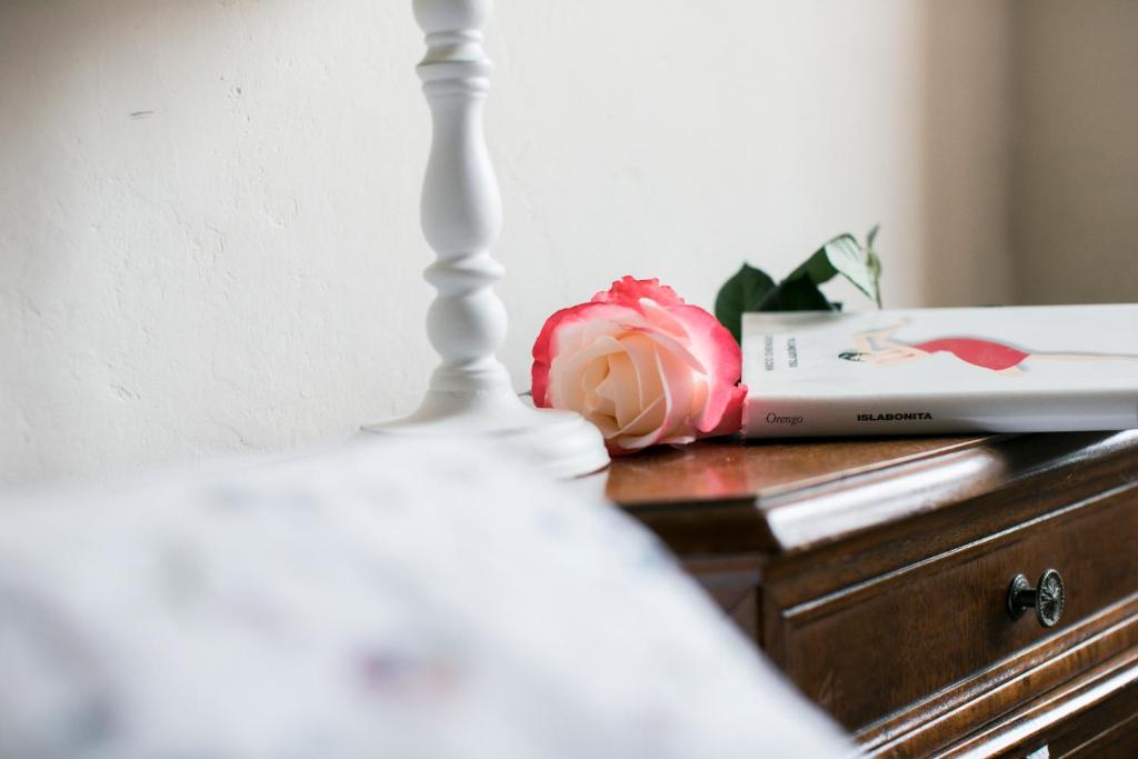 a flower sitting on a dresser next to a bed at BB Le Gemme in Dolceacqua