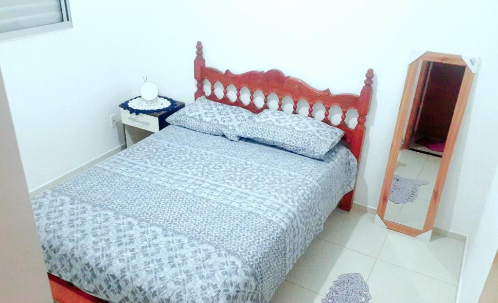 sypialnia z łóżkiem i lustrem w obiekcie Quarto em apartamento w mieście Suzano