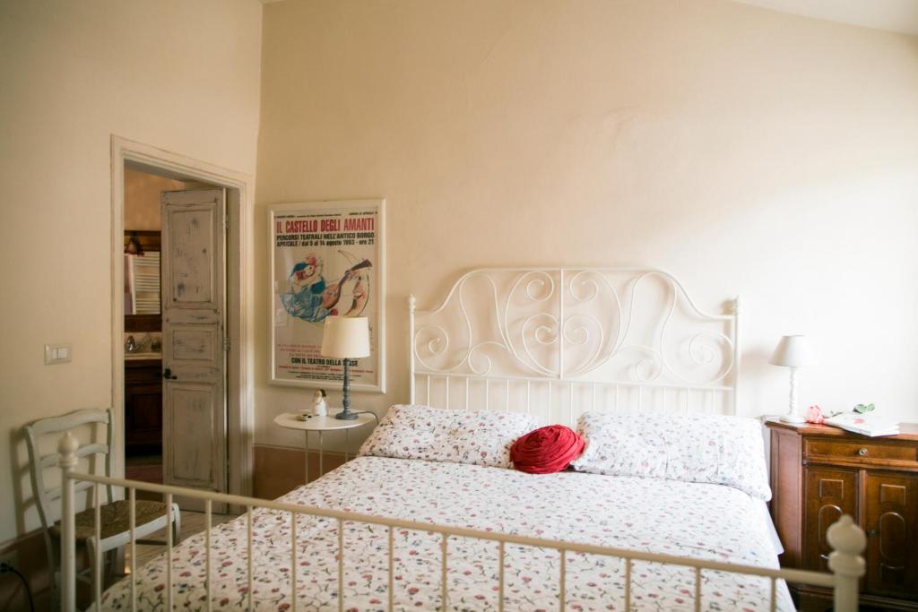 a bedroom with a white bed with a red pillow at BB Le Gemme in Dolceacqua