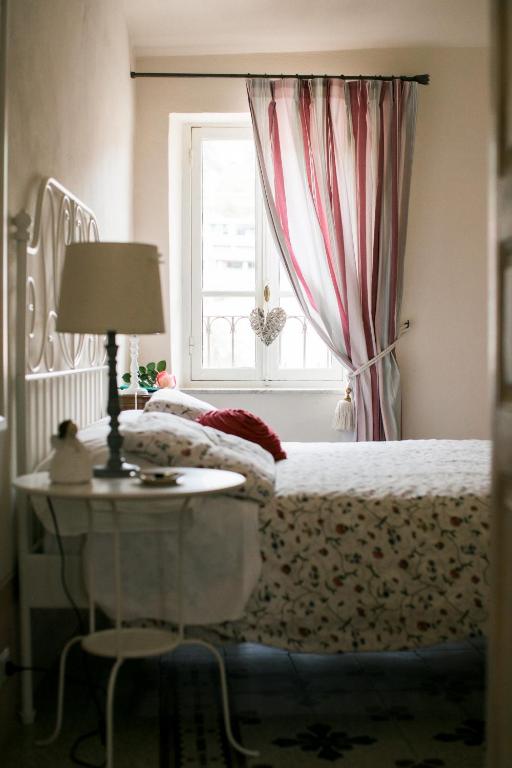 a bedroom with a bed and a table and a window at BB Le Gemme in Dolceacqua