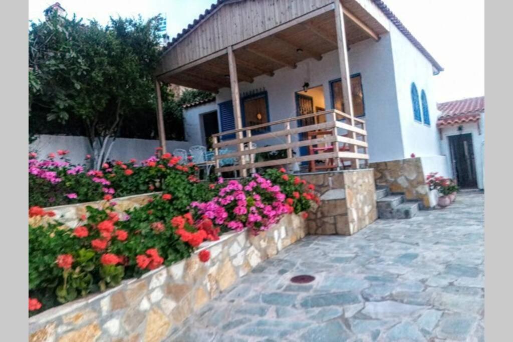 a house with a bunch of flowers in front of it at MAGIK HOME RELAXATION in Kalívia Thorikoú