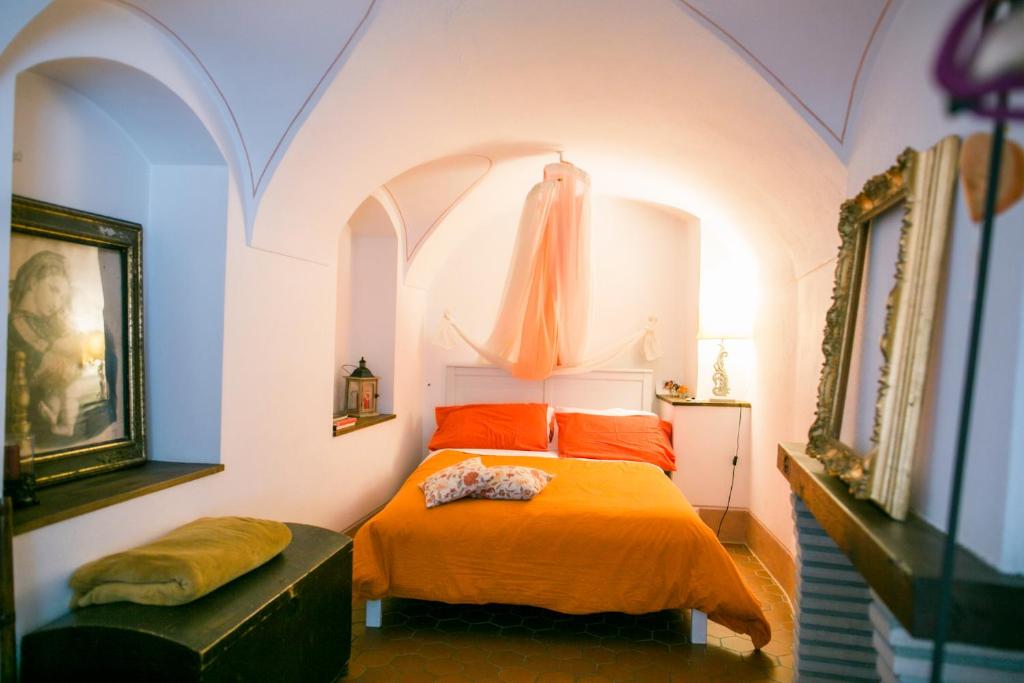 a bedroom with an orange bed in a room at BB Le Gemme in Dolceacqua