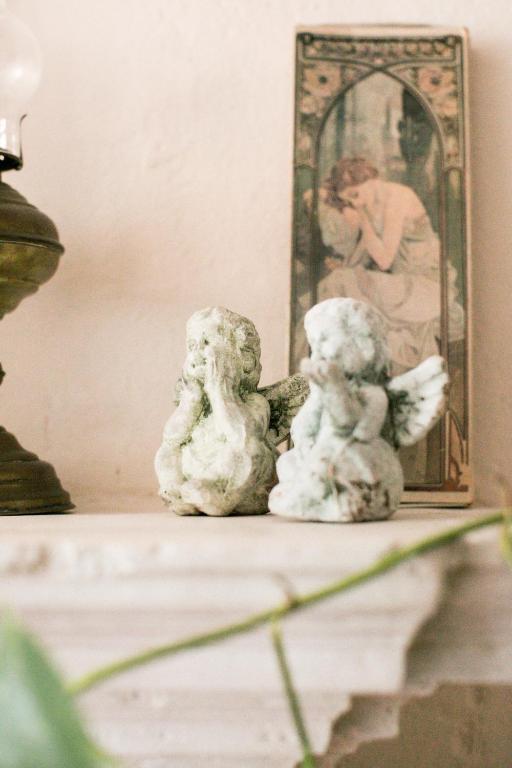 two angel figurines sitting on a table in front of a mirror at BB Le Gemme in Dolceacqua