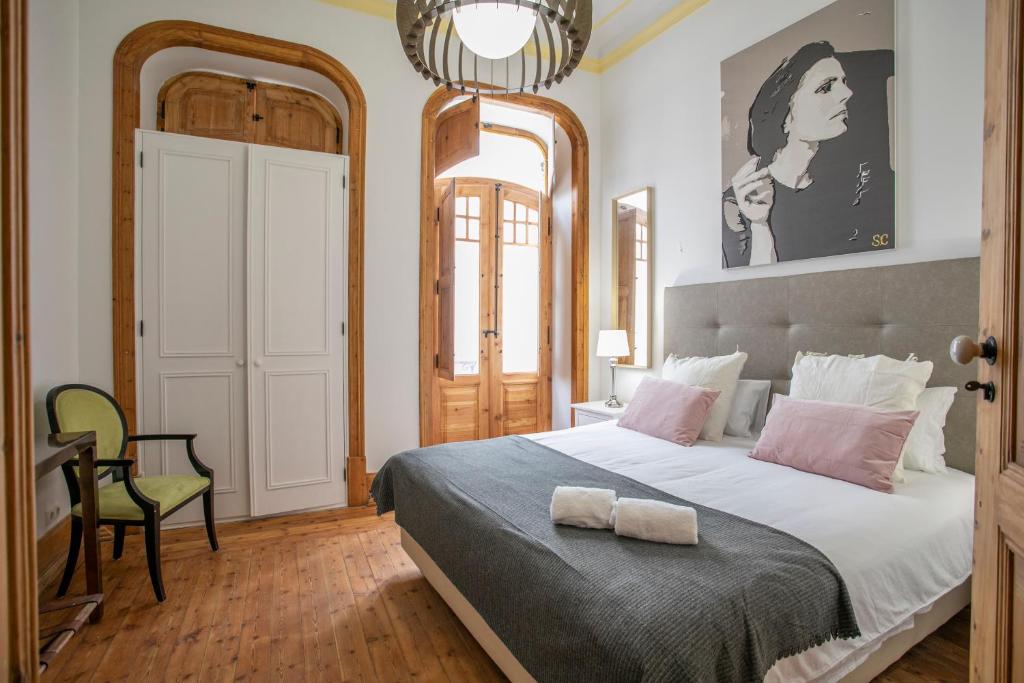 una camera da letto con un grande letto con due asciugamani di Apartamento ALIANÇA a Faro