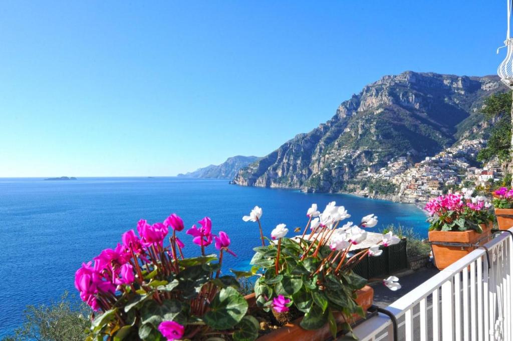 a view of the amalfi coast from a balcony with flowers at La Sorgente del Sole in Positano