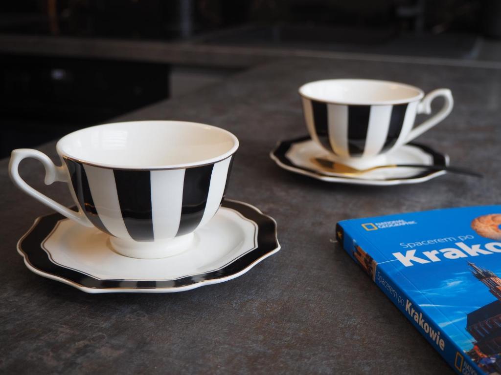 two coffee cups and a book on a table at Telimeny in Krakow