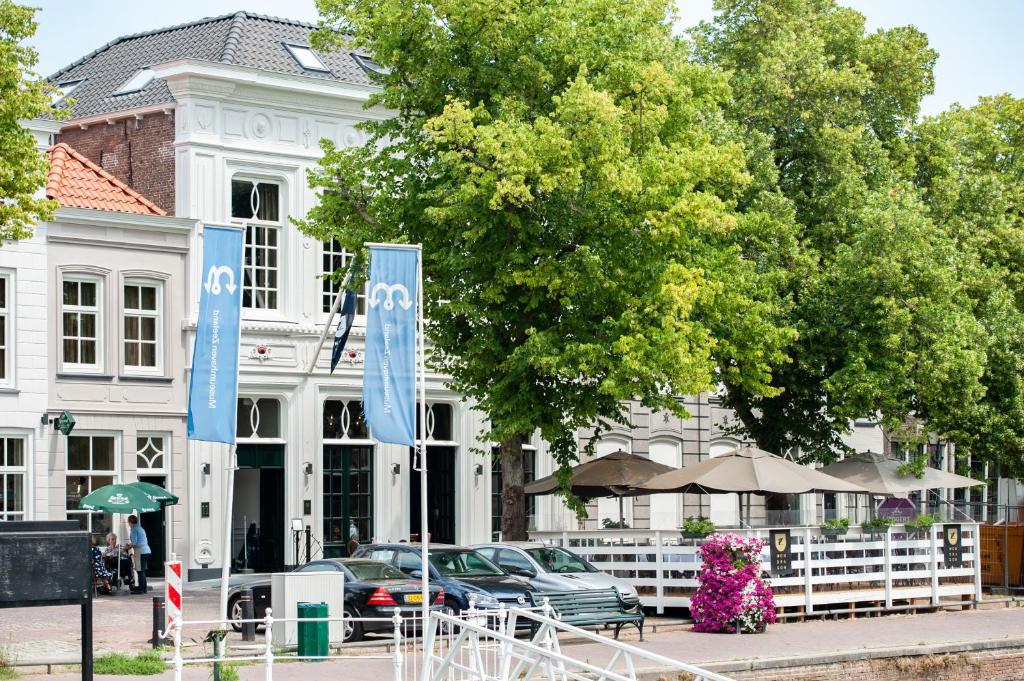 un edificio blanco con banderas azules delante de él en Résidence Zierikzee, en Zierikzee