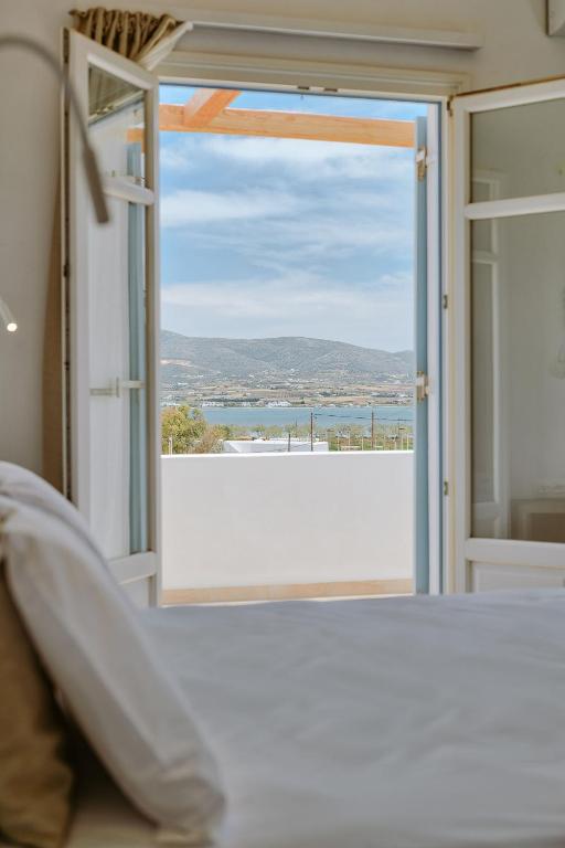 a bedroom with a view of the ocean through a sliding glass door at Agapi's Houses in Antiparos