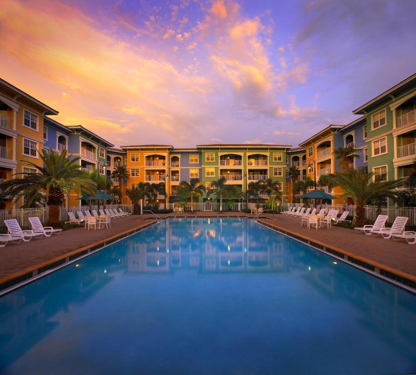 a pool at a resort with chairs and condos at Mizner Place at Weston Town Center in Weston