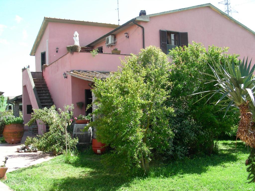 una casa rosa con árboles delante de ella en Agriturismo Da Paola, en Marsiliana